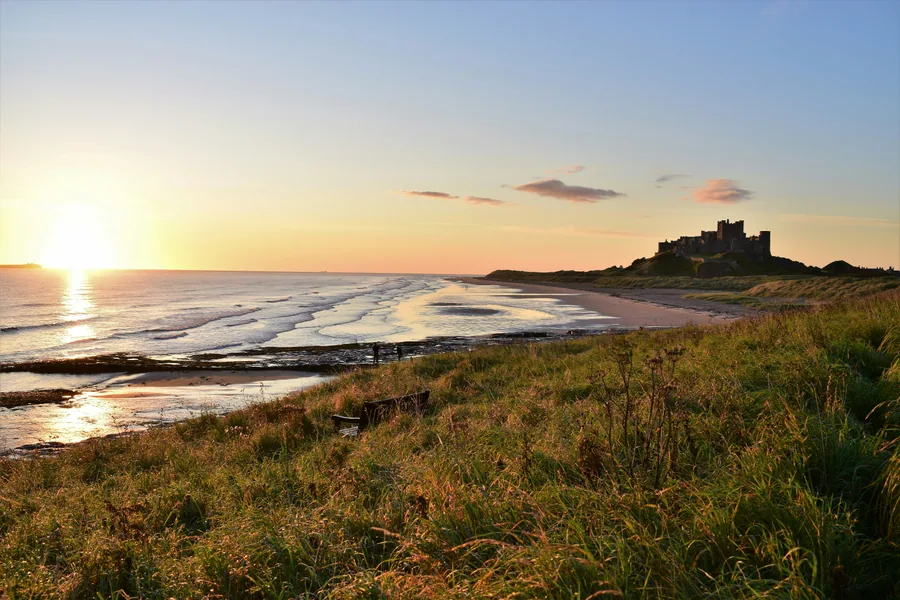 Castillo de Bamburgh junto a la costa de Northumberland al atardecer